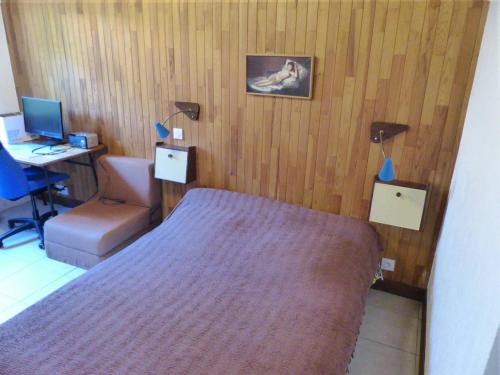 a bedroom with a bed and a desk with a computer at Villa SOROCA pour 8 personnes avec climatisation et wifi gratuit in Hossegor