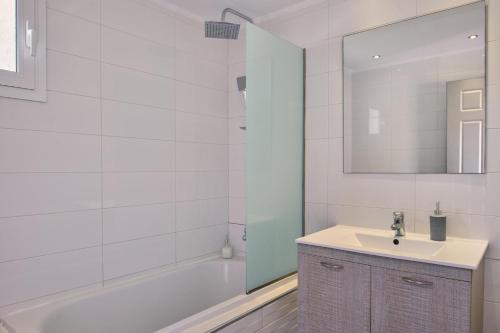 a bathroom with a sink and a tub and a mirror at Villa Kalliopi Periyali in Vasilikos