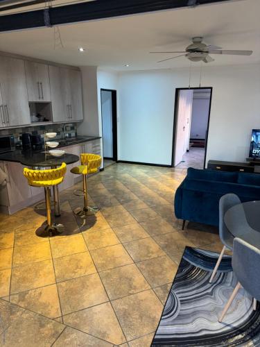 a living room with yellow chairs and a blue couch at Shalom in Cape Town