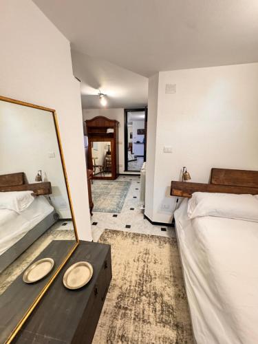 Un dormitorio con dos camas y un espejo. en GENOVA Suites SANT'UGO, en Génova