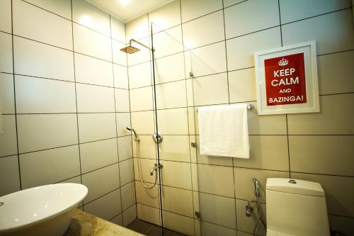 a bathroom with a toilet and a sign on the wall at Anara Service Apartments - Greater Kailash Part II in New Delhi