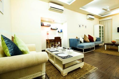 a living room with two couches and a table at Anara Service Apartments - Greater Kailash Part II in New Delhi