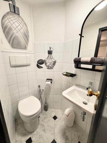 Un baño blanco con inodoro y lavabo. en GENOVA Suites SANT'UGO, en Génova
