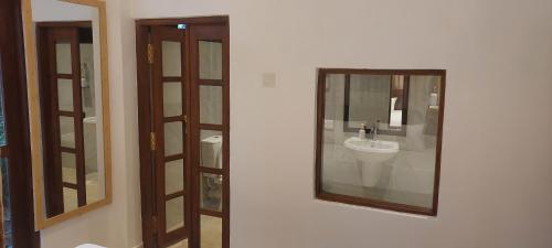 a bathroom with a sink and a mirror on a wall at Urban Isle Resort in Ahangama