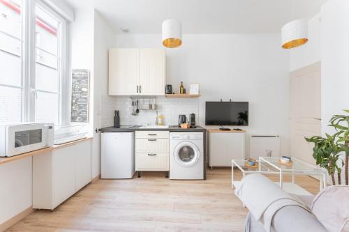 une cuisine avec des armoires blanches et une laveuse et une sécheuse dans l'établissement Moma - Au cœur du quartier Vaise, à Lyon