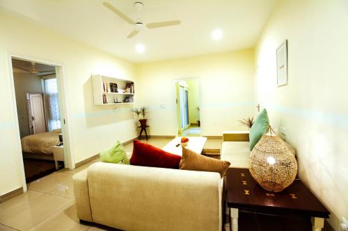 a living room with a couch and a table at Anara Service Apartments - Greater Kailash Part II in New Delhi