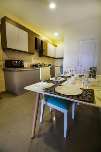 a kitchen with a table with chairs and a tableasteryasteryasteryasteryasteryastery at Anara Service Apartments - Greater Kailash Part II in New Delhi
