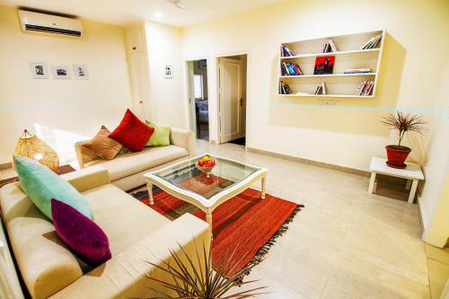 a living room with a couch and a table at Anara Service Apartments - Greater Kailash Part II in New Delhi