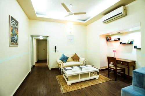 a living room with a couch and a table at Anara Service Apartments - Greater Kailash Part II in New Delhi