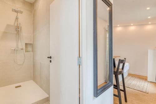 une salle de bain avec une douche avec une porte vitrée dans l'établissement Charming little house in th heart of Batignolles, à Paris