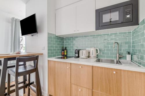 une cuisine avec un évier et un comptoir dans l'établissement Charming little house in th heart of Batignolles, à Paris