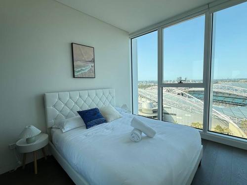 a bedroom with a large bed with a view of a stadium at 2BR apartment close to Accor Stadium in Sydney