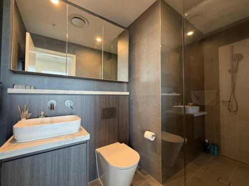 a bathroom with a sink and a toilet and a shower at 2BR apartment close to Accor Stadium in Sydney