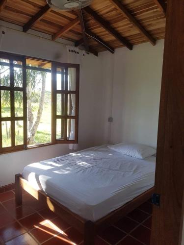 una camera da letto con un letto grande in una stanza con finestre di Cabañas bella vista a Barichara