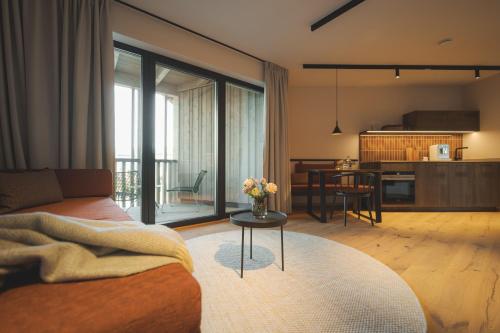 a living room with a couch and a table with a kitchen at Agrad Chalets in Aschau im Chiemgau