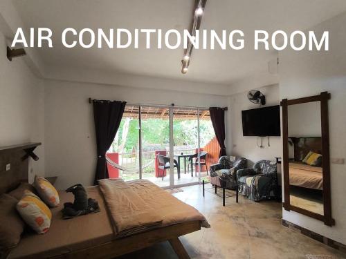 a living room with a couch and an air conditioning room at Sulu Sunset Beach Resort in Nauhang
