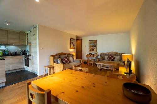 a kitchen and a living room with a wooden table at Terra Nostra A03 in Gryon