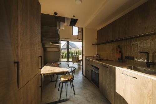 a kitchen with wooden cabinets and a table with chairs at Agrad Chalets in Aschau im Chiemgau