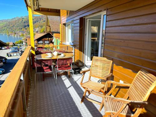 a balcony with chairs and a table on a house at SwissHut Stunning Views Alps Lake - Apart. Innerdorf in Sigriswil