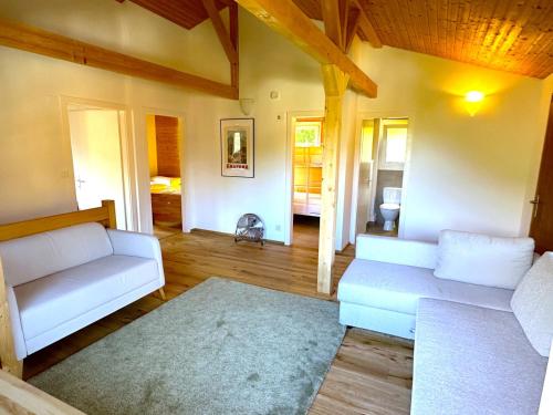 un soggiorno con 2 divani bianchi e un tappeto di SwissHut Stunning Views Alps - Chalet Flora a Beatenberg