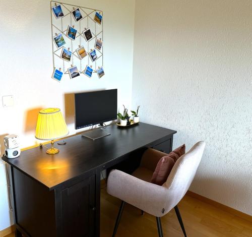 a desk with a chair and a monitor and a lamp at SwissHut Stunning Views Alps Lake - Apart. Ringold Up in Sigriswil