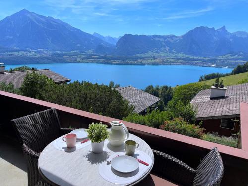 a table on a balcony with a view of a lake at SwissHut Stunning Views Alps Lake - Apart. Ringold Down in Sigriswil
