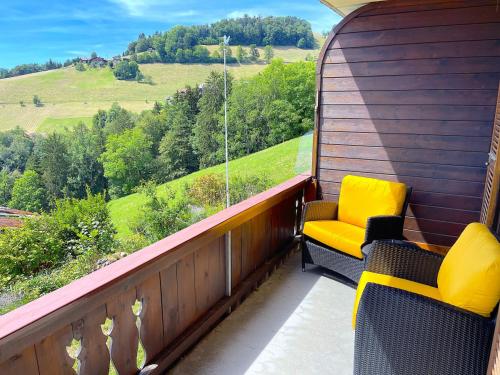 a balcony with two chairs and a view of a hill at SwissHut Stunning Views Alps Lake - Apart. Ringold Down in Sigriswil