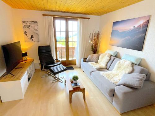 a living room with a couch and a tv at SwissHut Stunning Views Alps Lake - Apart. Ringold Down in Sigriswil
