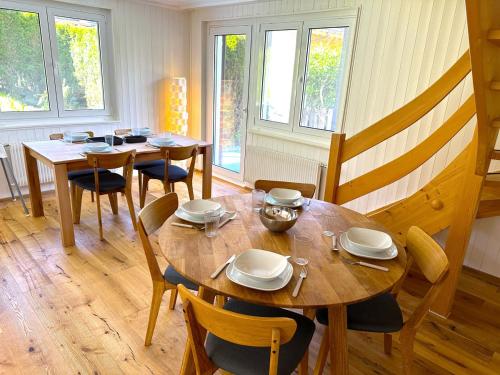 una sala da pranzo con tavoli, sedie e finestre di SwissHut Stunning Views Alps - Chalet Flora a Beatenberg