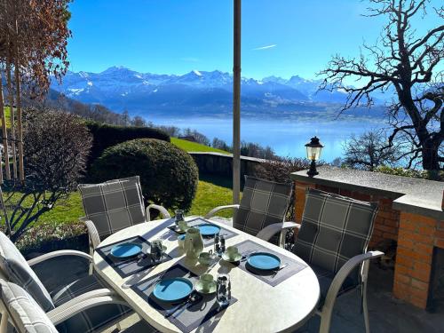 a table and chairs with a view of the mountains at SwissHut Stunning Views Alps Lake - Chalet Chrutzwag in Sigriswil