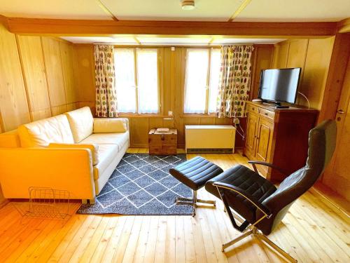 a living room with a couch and a chair at SwissHut Stunning Views Alps Lake - Chalet Erli in Därligen