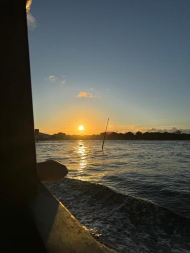 a boat in the water with the sunset in the background at Pousada Bela Vista in Ilha do Mel