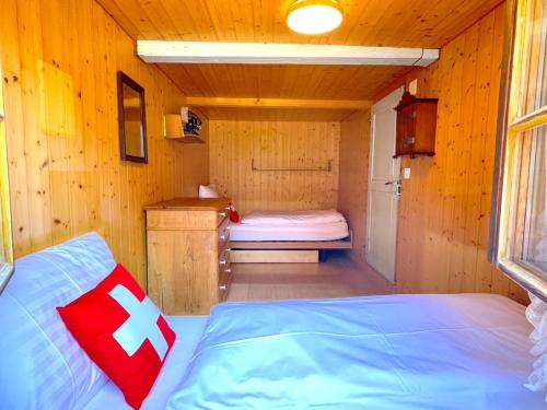a room with a bed in a wooden cabin at SwissHut Stunning Views Alps Lake - Chalet Erli in Därligen