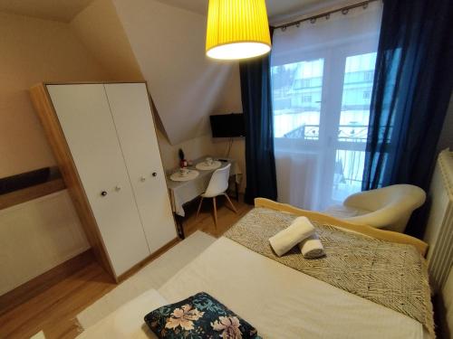 a small room with a bed and a small table at Tatrzańska Panorama in Gliczarów