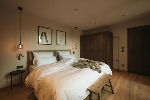 a bedroom with a large white bed with a wooden floor at Agrad Chalets in Aschau im Chiemgau