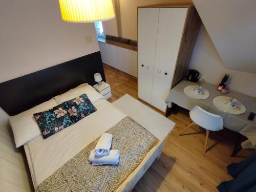 a small bedroom with a bed and a table at Tatrzańska Panorama in Gliczarów