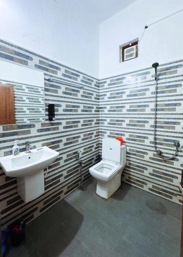 a bathroom with a toilet and a sink at VCS Apartments Parassinikadavu in Parassinikadavu