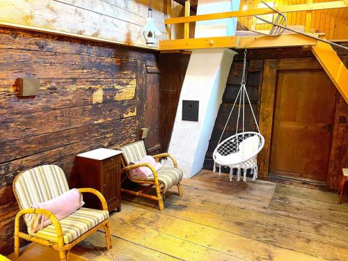 a porch with two chairs and a swing at SwissHut Stunning Views Alps Lake - Apart. Erli Down in Därligen