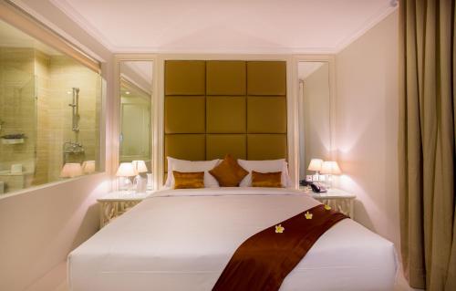 A bed or beds in a room at Amalfi Hotel Seminyak