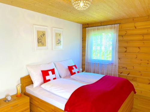 a bedroom with a bed with red and white pillows at SwissHut Stunning Views Alps Lake - Apart. Felden in Sigriswil