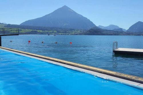a swimming pool with people in the water with a pyramid at SwissHut Modern Chalet with Spa - Chalet Beunden in Beatenberg