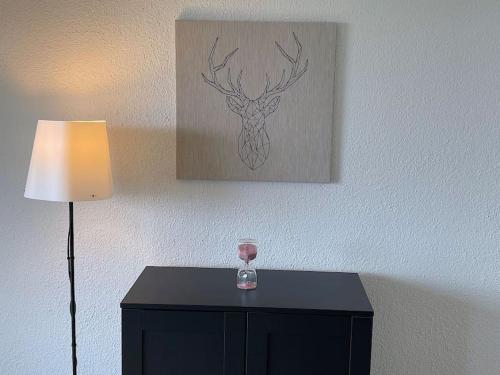 a wine glass on a table next to a lamp at SwissHut Stunning Views Alps Lake - Chalet Aeschlen in Sigriswil