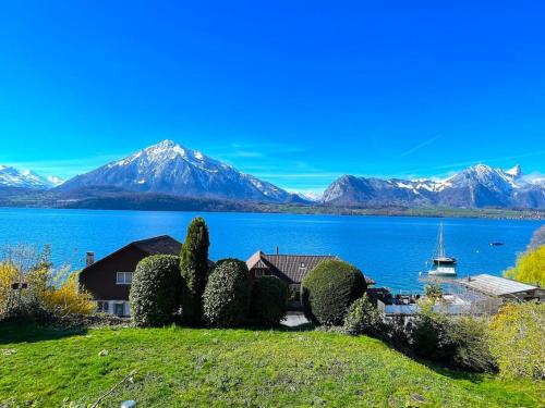 a house on the shore of a lake with mountains at SwissHut Stunning Views Alps Lake - Apart. Herzog 24 in Sigriswil