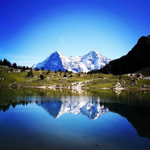 a mountain reflection in a body of water at SwissHut Stunning Views Alps Lake - Chalet Aeschlen in Sigriswil