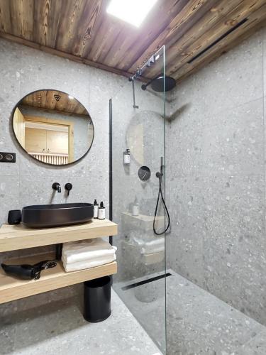 a bathroom with a sink and a glass shower at WOODHOME - Luxury Mountain Apartment Harrachov in Harrachov