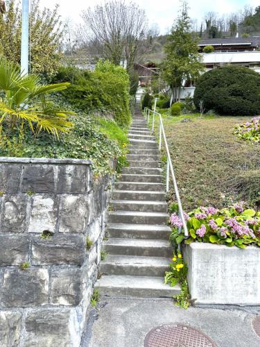 a set of stone steps leading up to a garden at SwissHut Stunning Views Alps Lake - Apart. Herzog 24 in Sigriswil