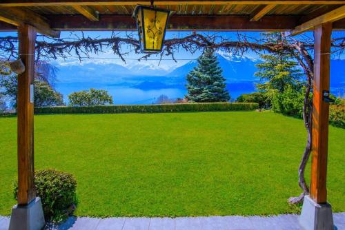 a view of a lawn from a pergola at SwissHut Stunning Views Alps Lake - Chalet Emmit in Sigriswil