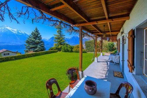 a patio with a table and chairs and mountains at SwissHut Stunning Views Alps Lake - Chalet Emmit in Sigriswil