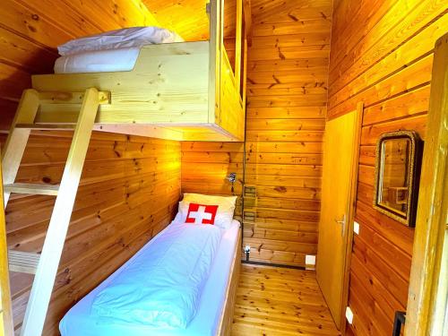 a small room with a bed in a wooden cabin at SwissHut Stunning Views Alps Lake - Chalet Emmit in Sigriswil