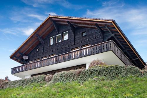 una casa en la cima de una colina en SwissHut Stunning Views Alps Lake - Chalet Antara, en Sigriswil